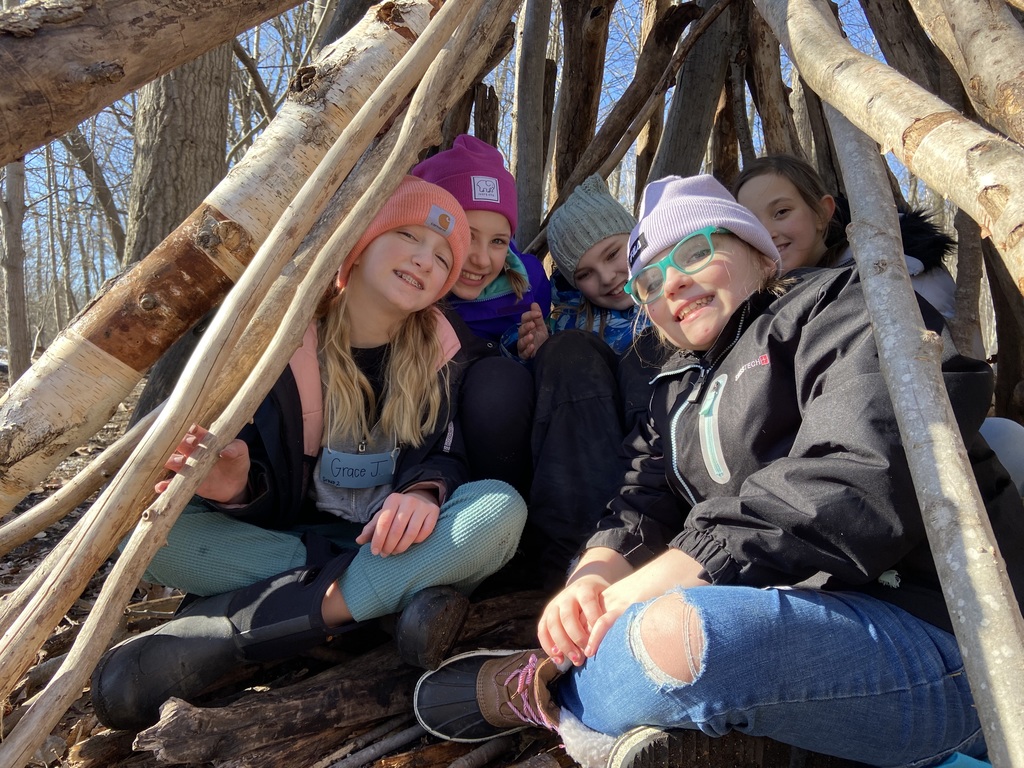 students in a wood shelter